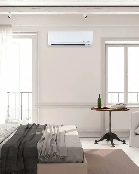 Mini-split ductless heating and air conditioning unit mounted on bedroom wall